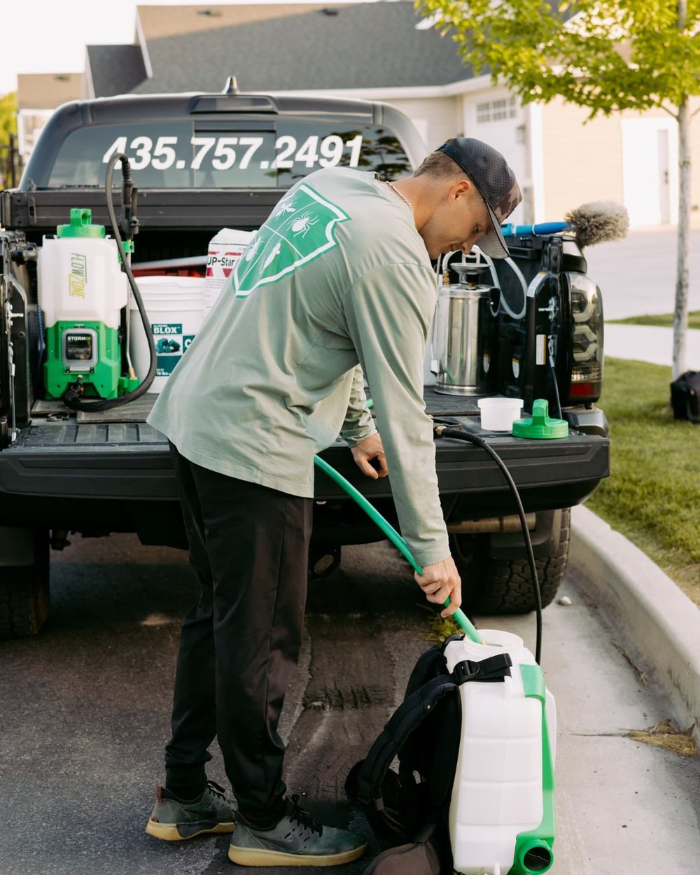 HomeGuard technician filling a sprayer before treating a Cache Valley home