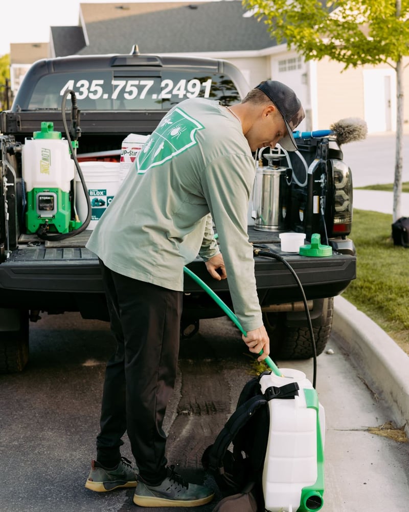 HomeGuard technician filling a backpack sprayer at the truck
