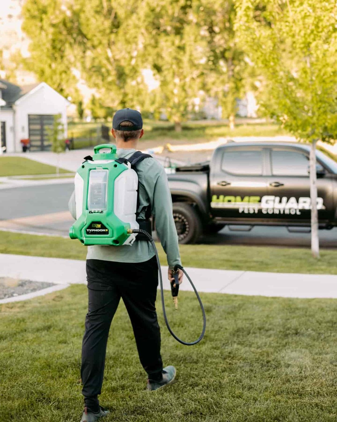 HomeGuard technician treating a home with a backpack sprayer