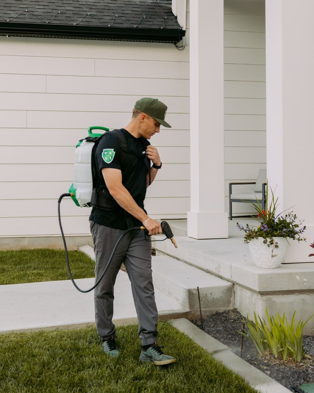 HomeGuard technician treating along a home porch and entry wall