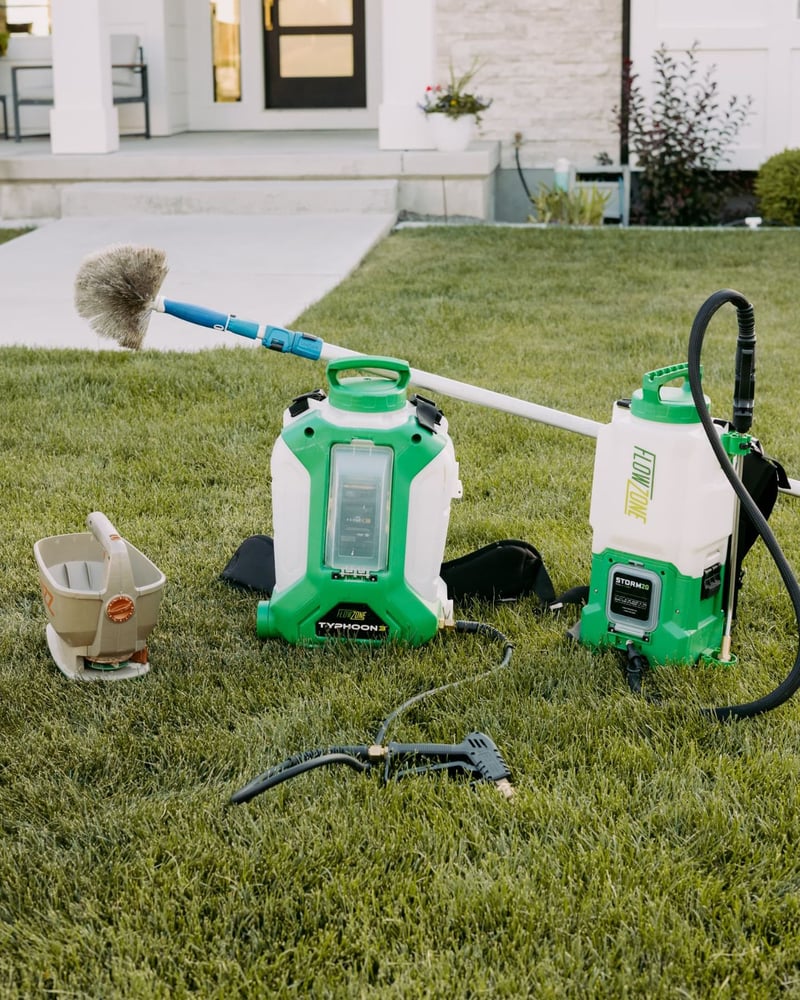 HomeGuard sprayers, duster and spreader staged on a front lawn